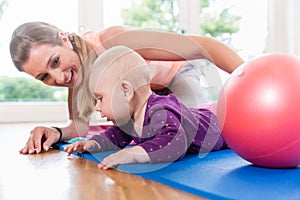 Mom and her baby practicing to crawl in mother and child course