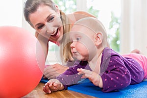 Mom and her baby practicing to crawl in mother and child course