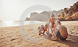 Mom and her children playing together on a sandy beach