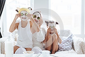 Mom with her daughters making clay face mask