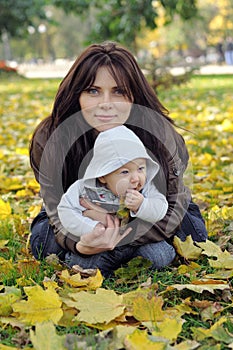 Mom and her little baby sitting on the grass