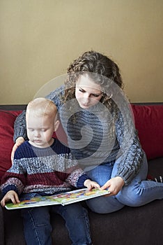 Mom with her little son is reading a book