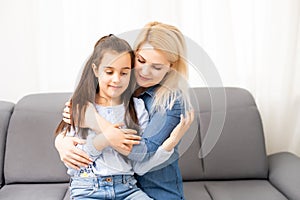 Mom with her pre teen daughter hugging, positive feelings, good relations.