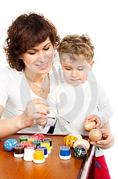 Mom with her son decorate Easter eggs