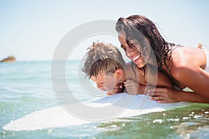 Mom with her teen son lying on a swimming board