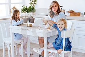 Mom with her two children sitting on the kitchen table.