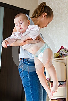 Mom holding baby. Mom cleans baby clothes