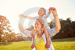 Mom holding daughter on shoulders