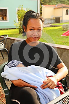 Mom holding newborn baby boy outdoor