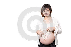 Mom holding small shoes for the unborn baby in the belly of pregnant women