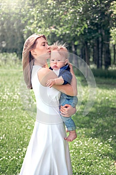 mom holds the baby in her arms and kisses him