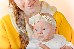 Mom holds the baby in her arms and poses for the camera in the studio, the concept of love and unity and care for loved ones and