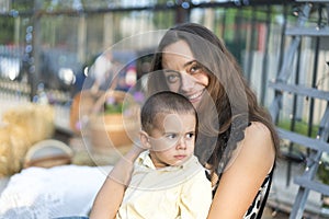 Mom holds a child in her arms. A happy family. Young mother holding her baby in her arms and stroked my mother& x27;s child litso.