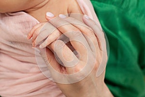 Mom holds the hand of a newborn baby. Love and tenderness. Mothers Day