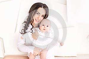 Mom holds newborn baby in her arms at home, happy loving family concept, mother`s day