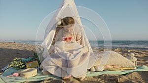 Mom hugging daughter in warm fluffy blanket on beach, kissing cute daughter 4K