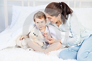Mom hugs baby at home on the bed, the concept of family and children, mother`s day