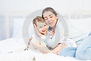 Mom hugs baby at home on the bed, the concept of family and children, mother`s day