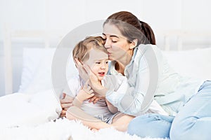 Mom hugs baby at home on the bed, the concept of family and children, mother`s day