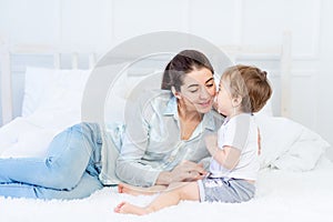 Mom hugs baby at home on the bed, the concept of family and children, mother`s day