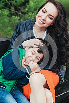 Mom hugs her little son in the park. A mother`s love and tenderness