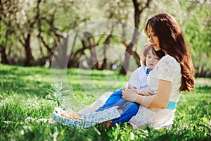 mom hugs sad toddler son outdoor on the walk. Happy loving family