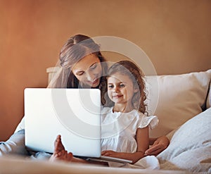 Mom installed some educational apps for her to enjoy. a mother and her little daughter using a laptop together at home.
