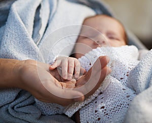 Mom keeps miniature hand newborn baby in hands