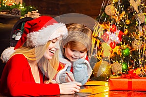 Mom and kid play together christmas eve. Happy family. Family holiday. Santa claus coming. Mother and little child boy