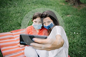 Mom and kid wearing masks while lying in park