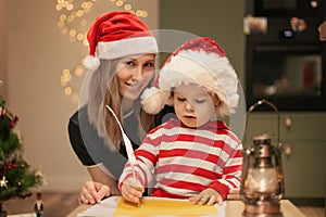 Mom and kid write wishlist to Santa, Happy family holiday, Christmas Eve at home