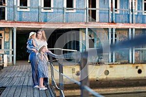 Mom and kids in blue clothes standing old bridge