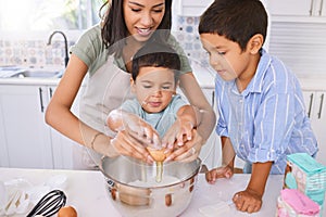 Mom, kids and kitchen for baking, cooking or cake in home while excited, happy or smile on face. Mother, boy and