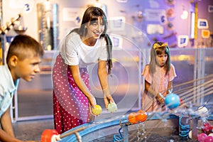 Mom with kids playing in a science museum