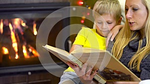 Mom and kids reading book at christmas time