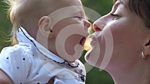 Mom kisses smiling baby in the face