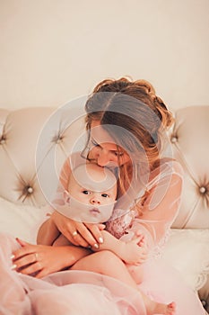 Mom kissing baby boy in bedroom