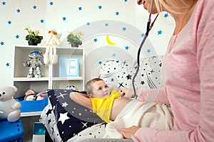 Mom listens to the heartbeat of the phonendoscope to her son.