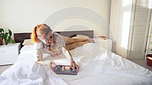 Mom and little boy in the morning watching tablet in bed