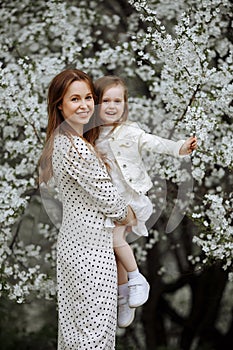 Mom and little daughter in the apple orchard