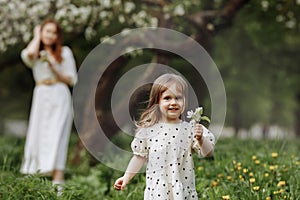 Mom and little daughter in the apple orchard