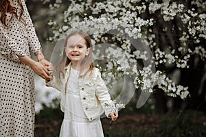 Mom and little daughter in the apple orchard