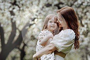 Mom and little daughter in the apple orchard