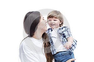 Mom and little son laugh and hug. A young brunette with long hair in a white T-shirt and jeans with a boy in jeans and a blue