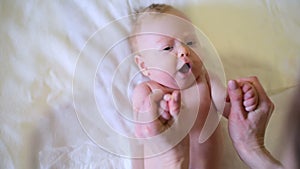 Mom makes gymnastics with baby  Female hands holds the baby by arms and does exercises with him