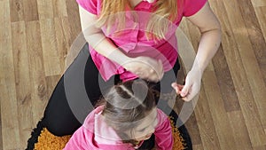 mom makes her daughter's hair. combing her hair with a comb. Mom takes care of daughter, morning procedures. hands of