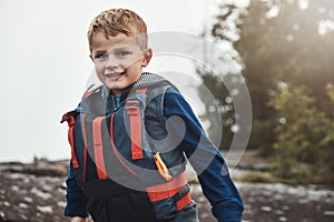 Mom makes sure that Im always save as can be. Portrait of a cheerful little boy wearing a lifejacket while looking at