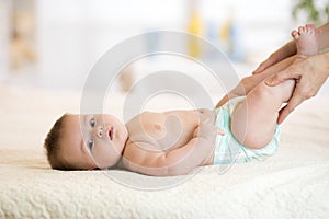 Mom or massagist doing gymnastics baby photo