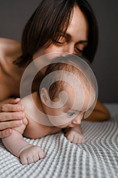 Mom, mummy, young mother with little baby daughter. Breast-feeding. Mum kissing,hugging child. Newborn cute happy girl