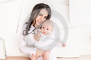 Mom with a newborn baby in her arms at home, the concept of a happy loving family, mother`s day